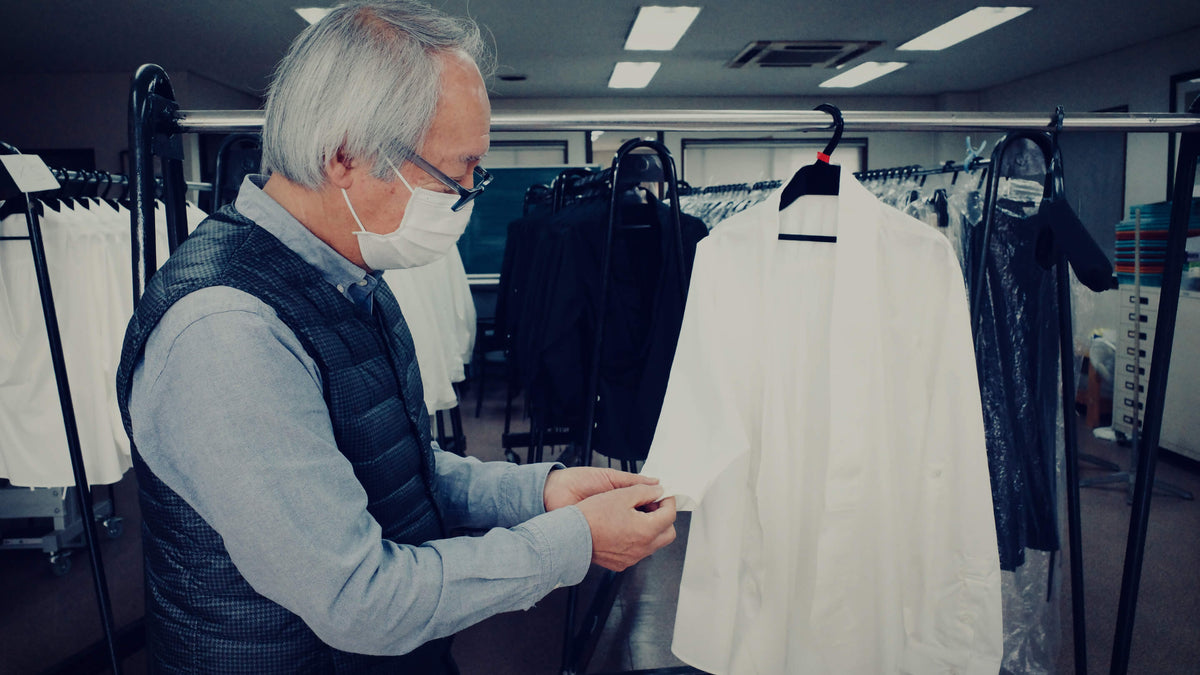 縫い上がった一着を検品するコンシェルジュの藤沼