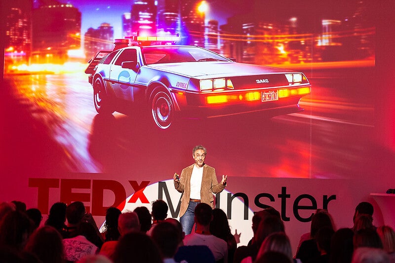 TEDxMünsterの舞台で白いSamurai Mode Shirtを着て登壇するTobias Gantner